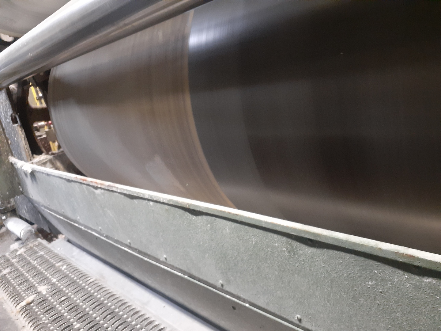 Paper mill dryer can spinning at production speed while Radiant cleaning lifts buildup from its surface
